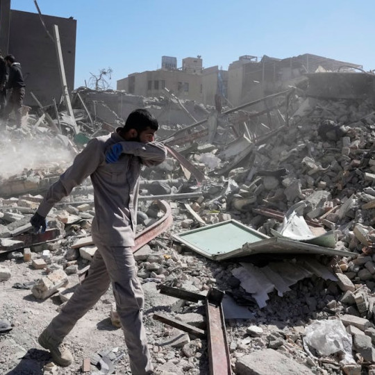 Men inspect the ruins of a police station in Tehran, Iran.