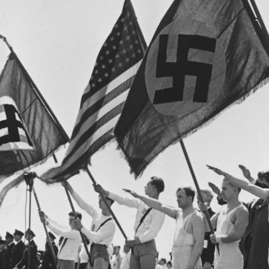 People holding and saluting the American and Nazi flags.