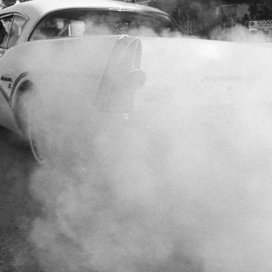 1950s car spewing exhaust.