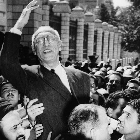 Prime Minister Mohammad Mosaddegh being lifted up in a crowded street.