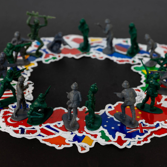 Plastic play soldiers all facing each other on top of stickers of countries.