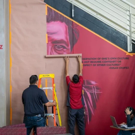 Crew covers a mural of Cesar Chavez mural at Santa Ana College