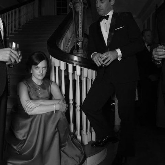 A still from Mad Men of a woman surrounded by men.
