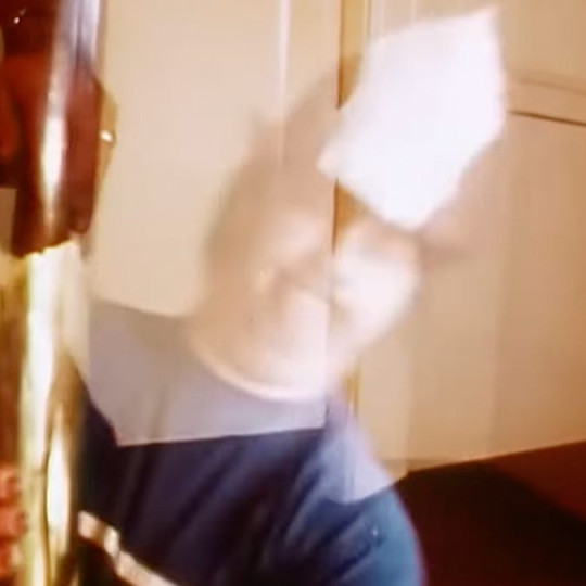 Brian Wilson in a fireman's hat grabbing a fire pole, from the music video for 