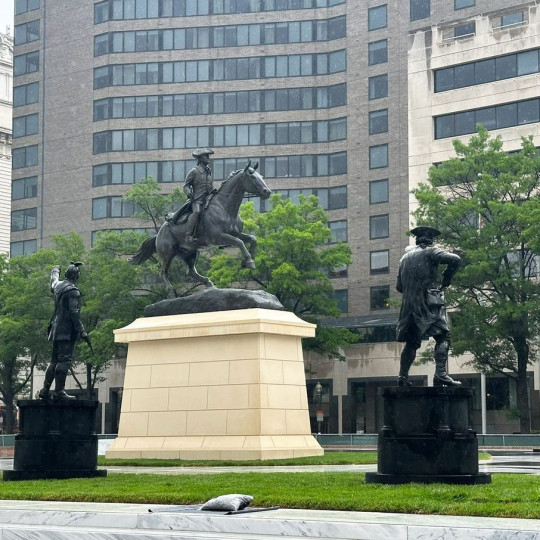 A towering statue depicting Caesar Rodney on horseback atop a large pedestal in Freedom Plaza.