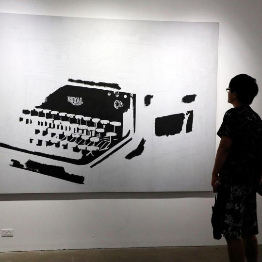 Young people view an Andy Warhol print depicting a typewriter.