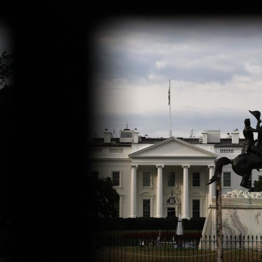 White house seen through a fence.
