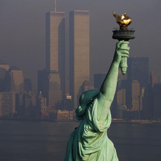 A view of the Statue of Liberty with the twin towers in the background