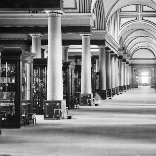 Model room at the U.S. Patent Office, with rows of glass cases containing inventions.