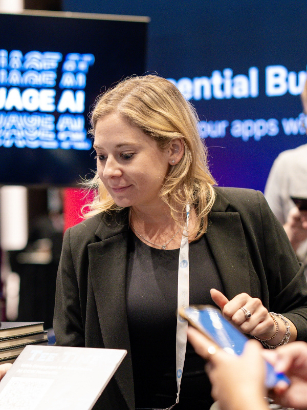 A person in a blazer is looking at documents. A sign in the background partially reads "POTENTIAL BU.