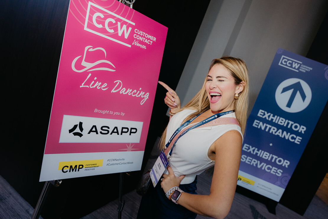 A woman poses playfully next to a pink sign for "Line Dancing" at a Customer Contact Week event, with exhibitor entrance signs visible in the background.