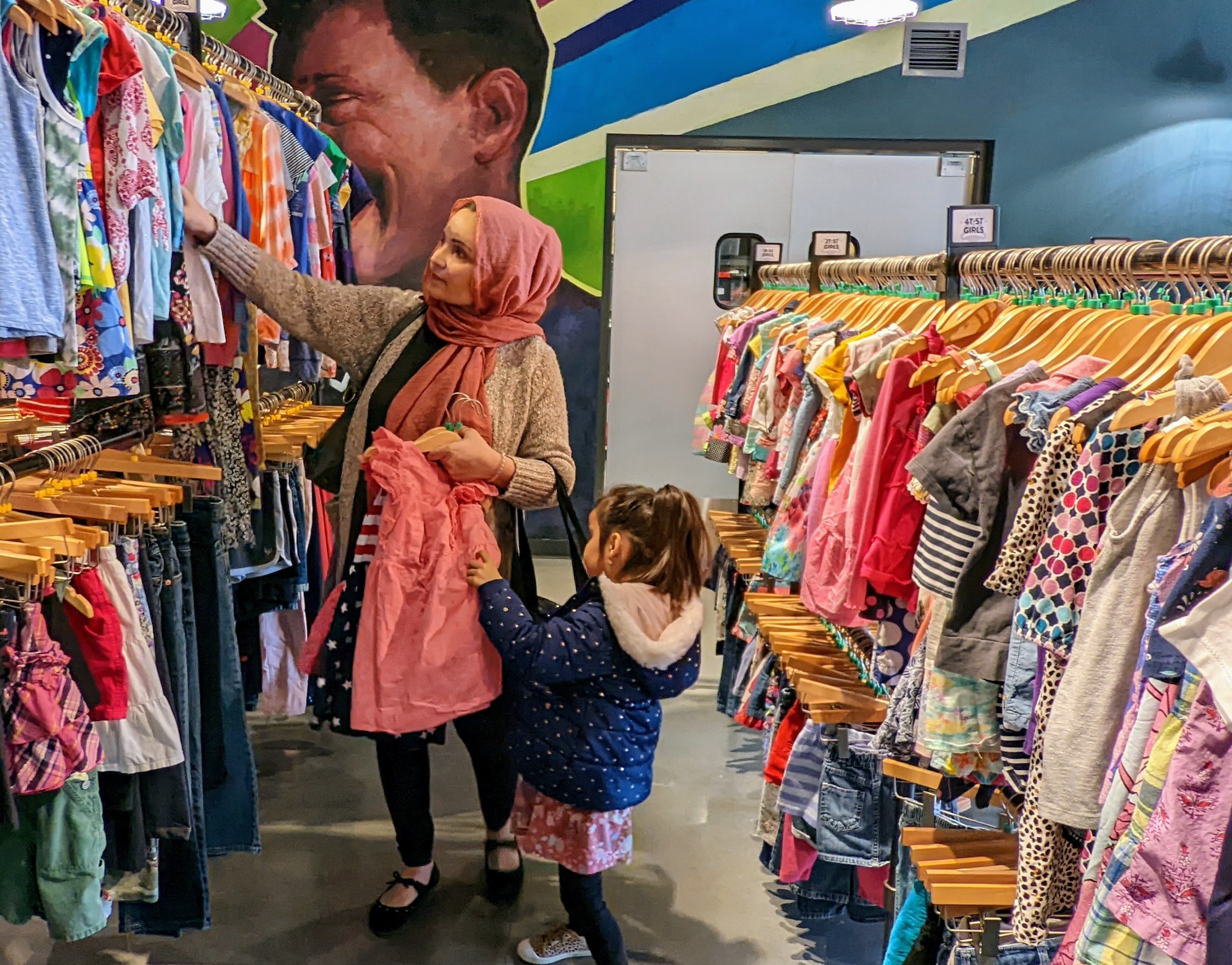A mother and her daughter shop for clothes at the care center.