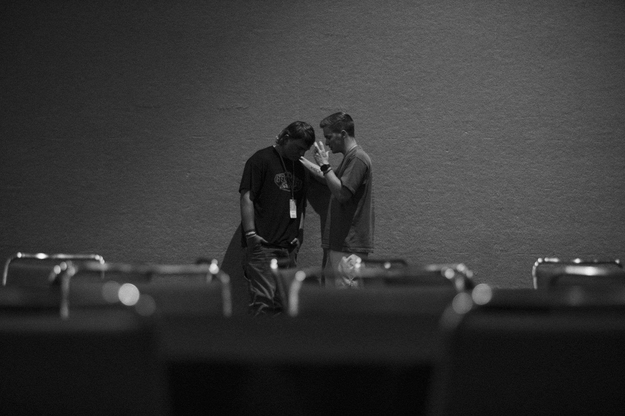 Two men are praying off in the distance near a far wall.
