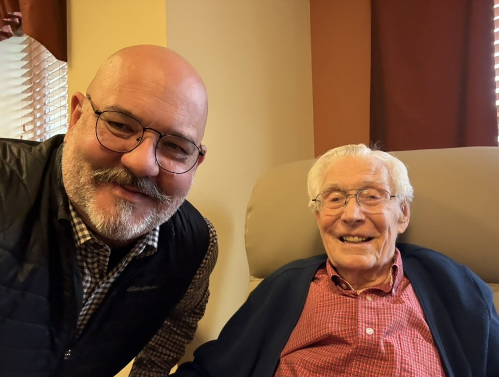 Two smiling men, one older and one middle-aged