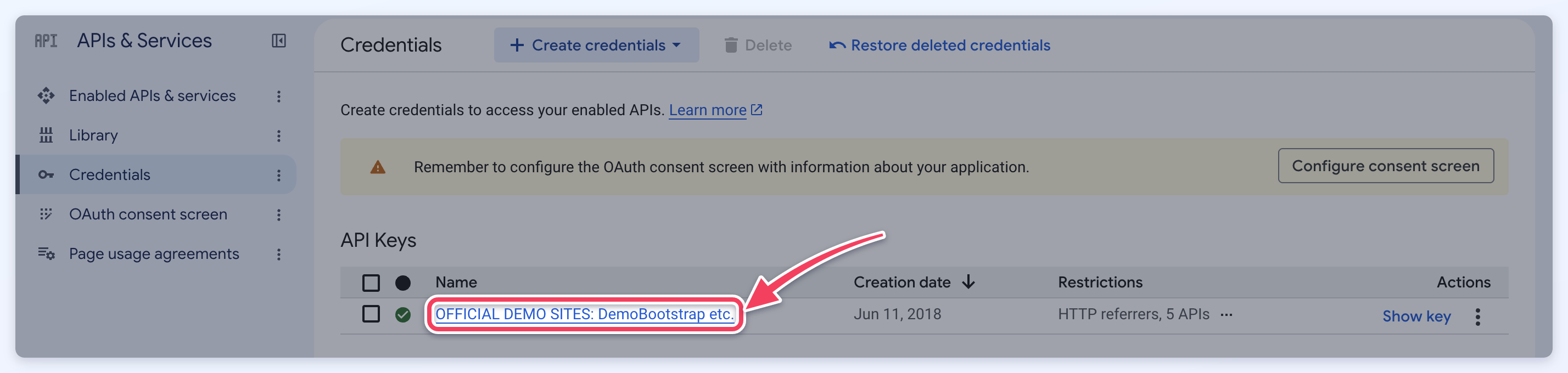 The API Keys list on the Credentials page, with an arrow pointing to the key's name, which opens the key's settings.