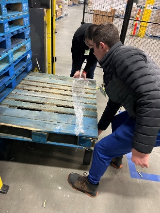 A group of men working on a pallet

Description automatically generated