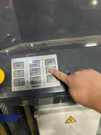 A finger pressing a button on a machine

Description automatically generated