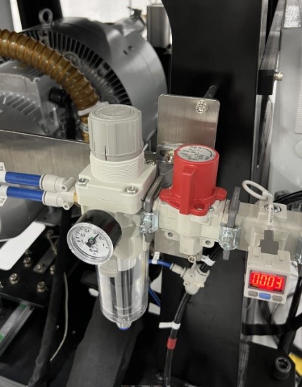 Close-up of a machine with a pressure gauge

Description automatically generated