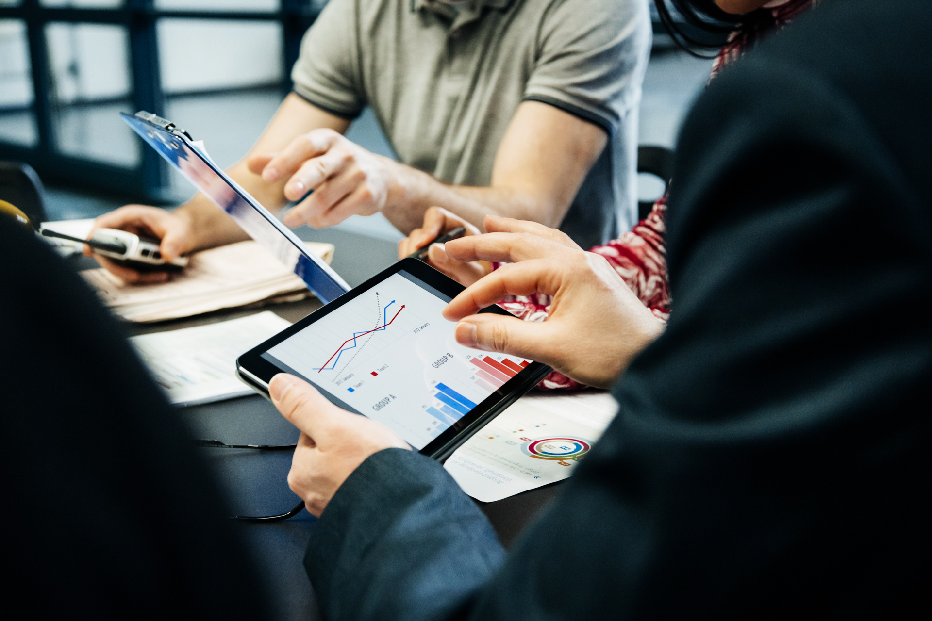 Hands reviewing charts on a tablet