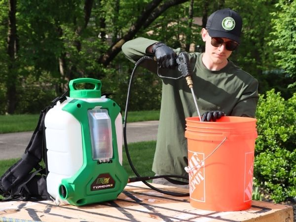 man spraying into a bucket
