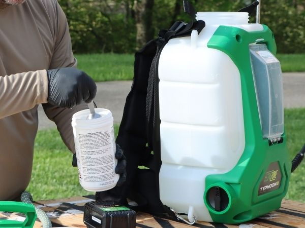 man adding spray tank cleaner to a flowzone sprayer