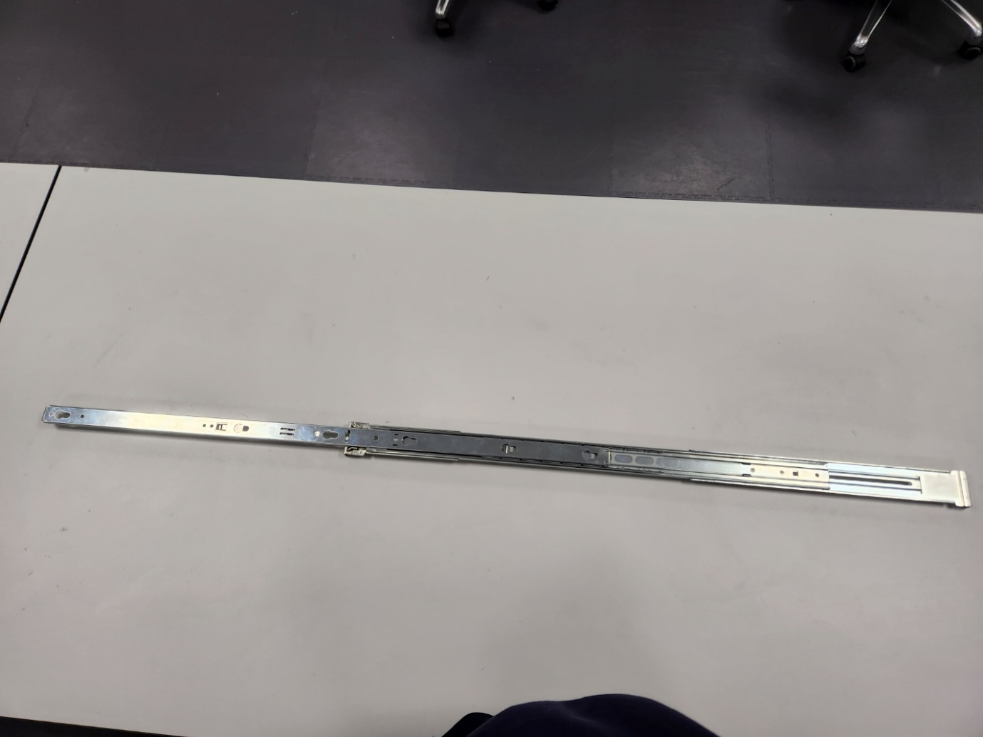 A long metal rod on a table

Description automatically generated