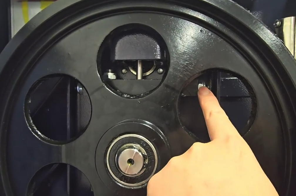 Pivot block nylon lock nut locations on upper flywheel assembly