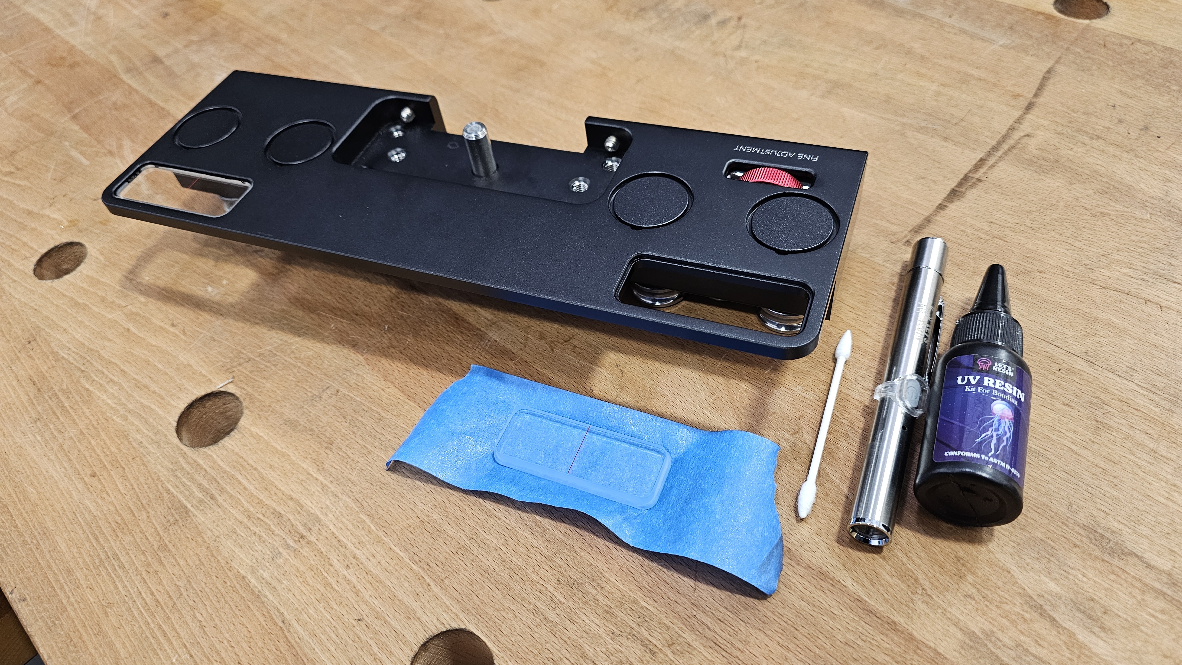 Step 5 — slider body with viewer on tape, UV resin, UV light pen and Q-tip all staged