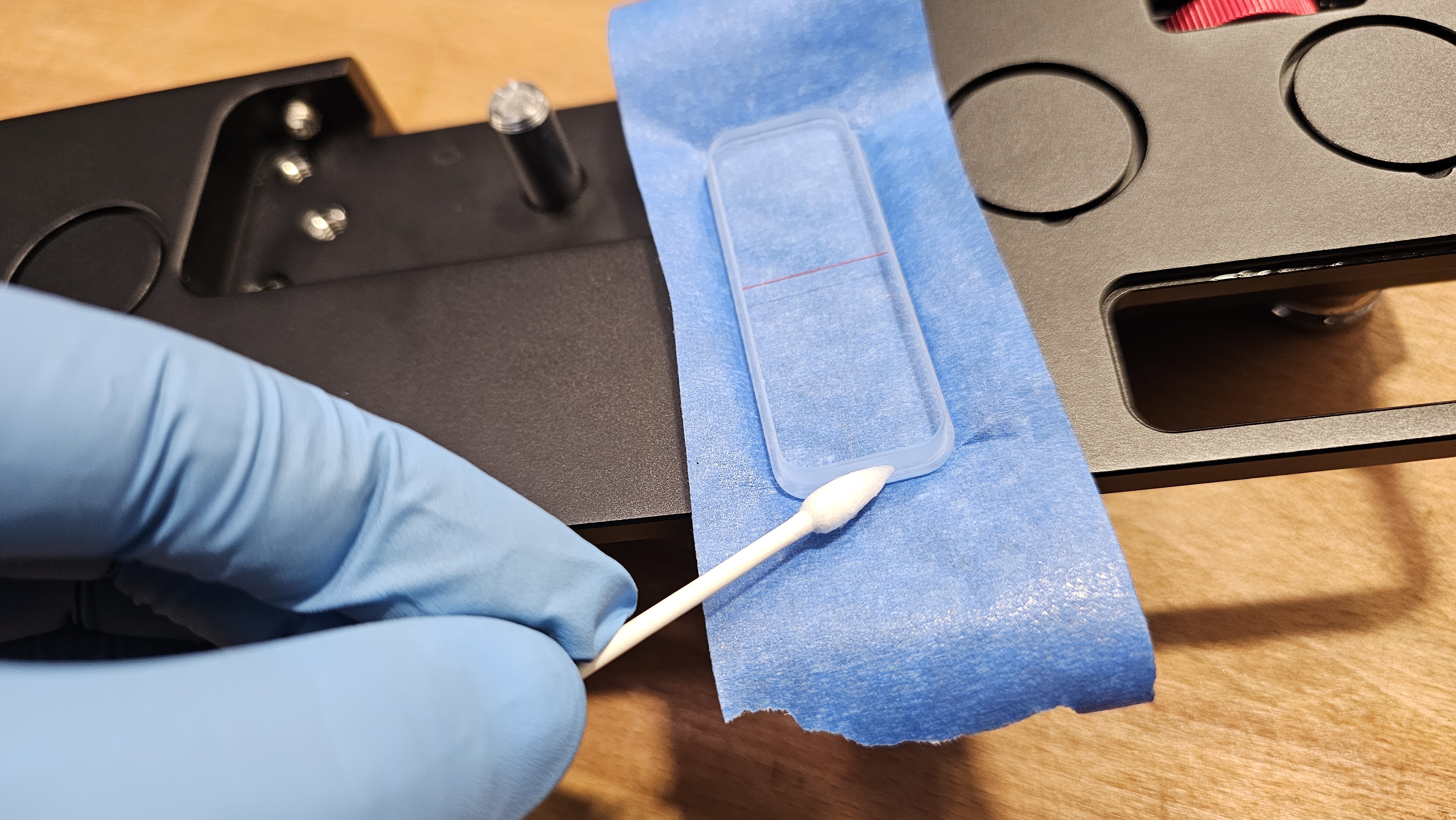 Step 8 — Q-tip applying thin UV resin layer to the outer seam of the viewer now seated in socket