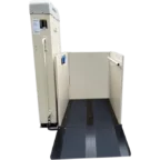 A beige wheelchair lift with a platform and side rails, designed to assist individuals in accessing elevated surfaces.