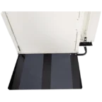 Close-up of a wheelchair ramp with a non-slip surface, leading to a platform or doorway.