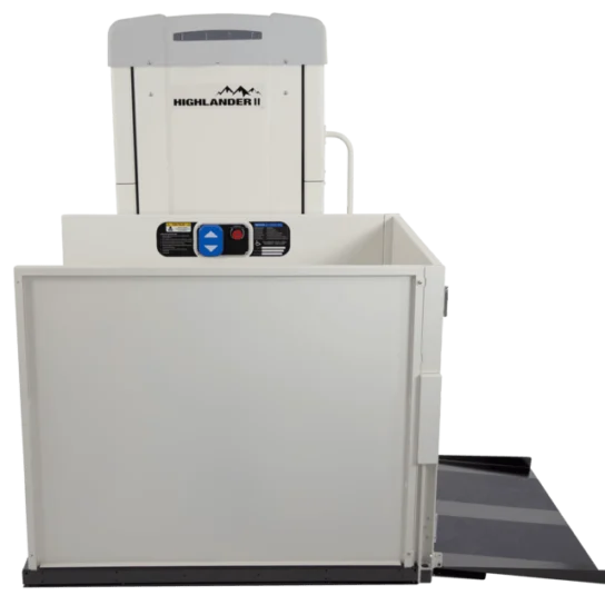 Vertical platform lift with a safety gate, control buttons, and a ramp, used for accessibility and mobility support.