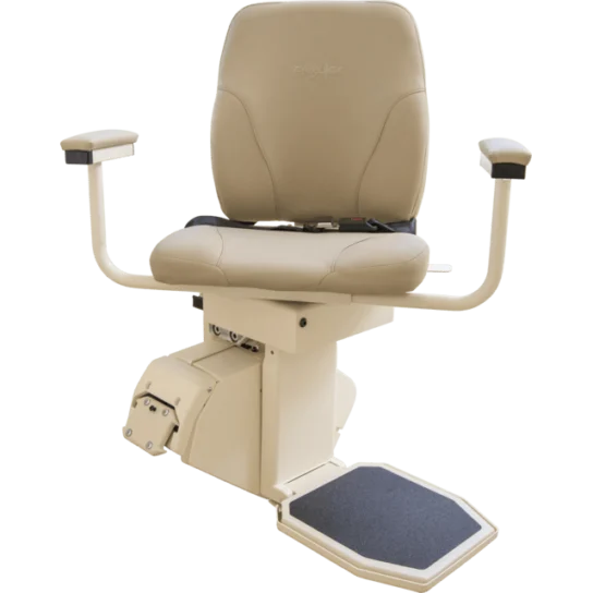 A beige stair lift chair with padded seat, armrests, and a footrest, mounted on a motorized platform.