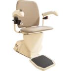 A beige stairlift chair with armrests and a footrest, designed for safe and easy movement up and down stairs.
