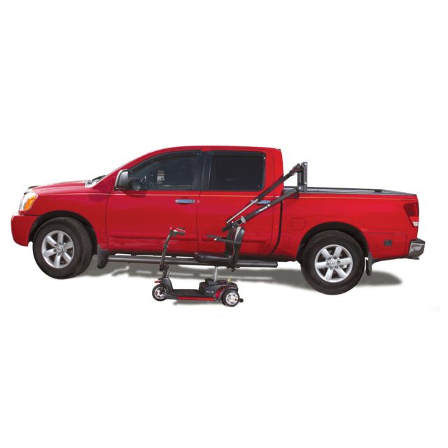 Red pickup truck with a mobility scooter lift attached to the bed, holding a small scooter next to the vehicle.