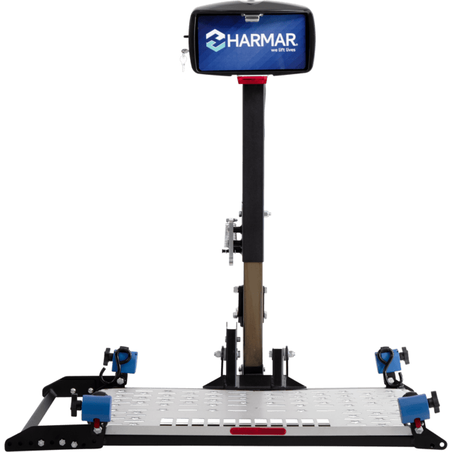 Harmar wheelchair lift with a platform and vertical support bar, featuring blue securing straps and a digital screen displaying "Harmar".