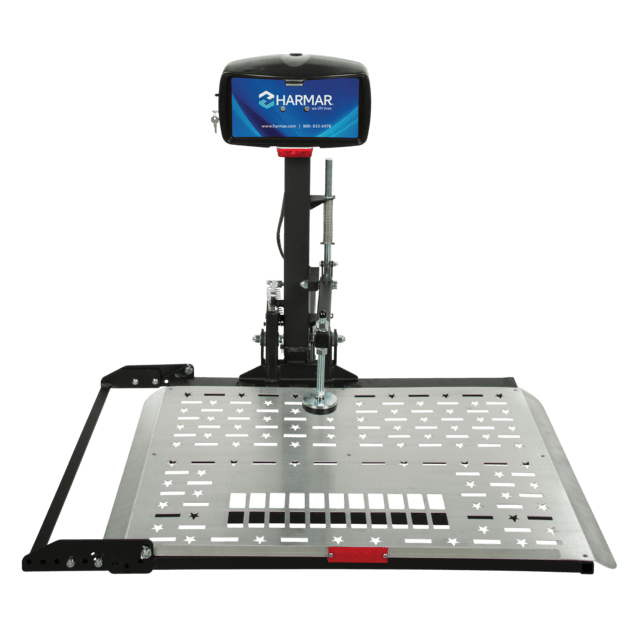 A platform lift with a monitor displaying the Harmar logo, designed for transporting mobility devices, featuring a durable metal platform and a securing mechanism.