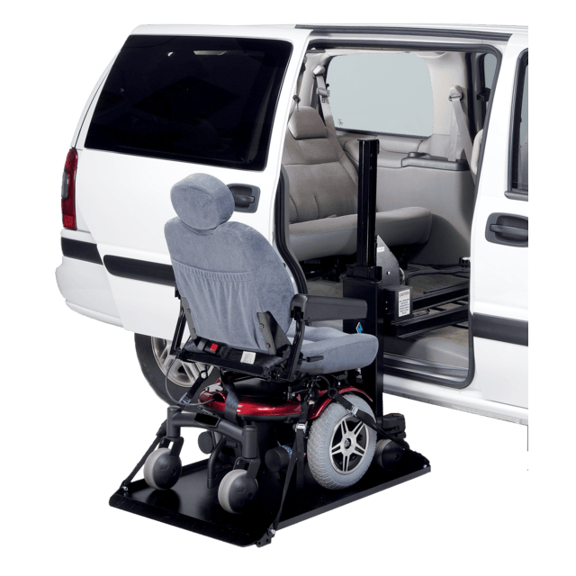 Wheelchair lift deploying from a white van, showing the interior seat aligned with the vehicle's open side door.