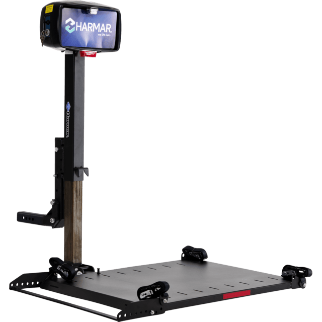 A Harmar car lift platform designed for wheelchairs and scooters, with a vertical post and a platform with straps for secure transport.