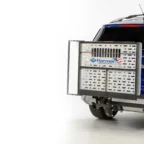 Blue SUV with a Harmar AL301XL lift attached to the rear, featuring a metallic platform for mobility devices, against a white background.