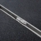 Close-up of a metal hinge embedded in a textured, dark surface, possibly part of a folding mechanism.