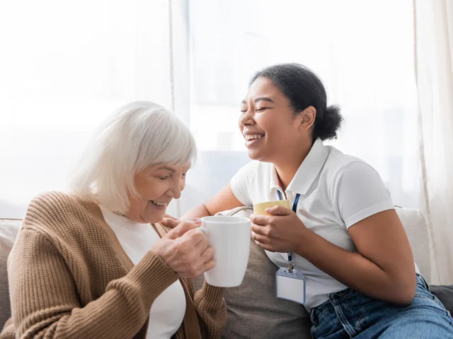 Caregiver with senior woman laughing