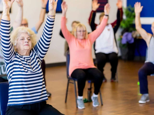 Senior citizens participating in chair exercises