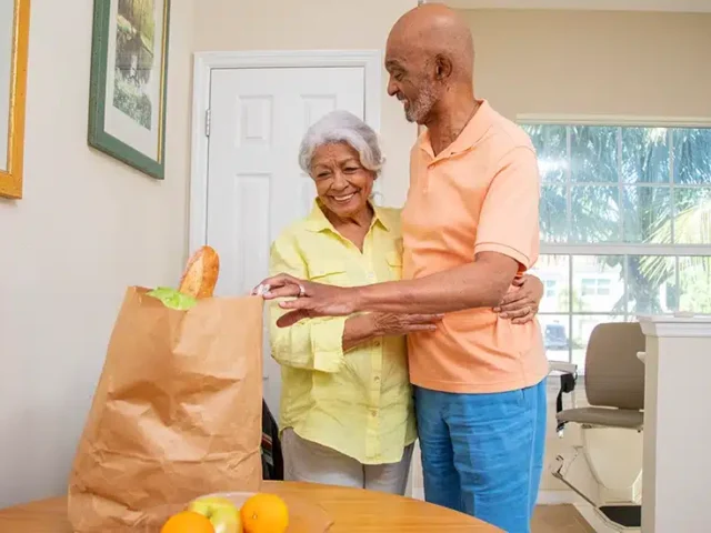 husband hugging wife with stairlift behind them