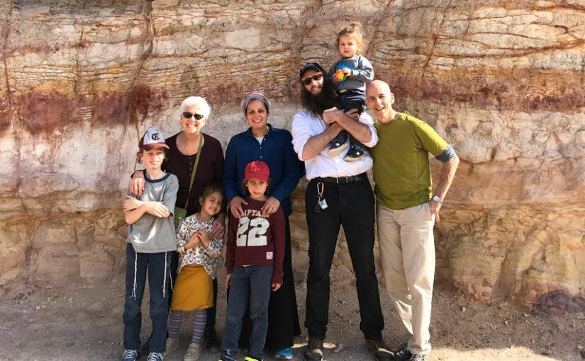 family posing for a picture by a rock wall