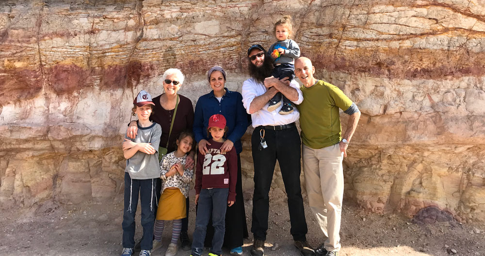 family posing for a picture by a rock wall