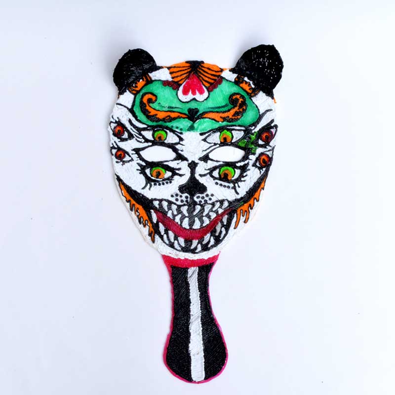 Decorated Halloween mask created with a 3D pen on white surface.
