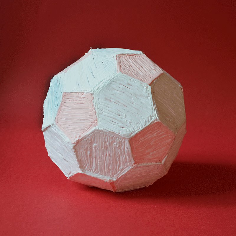 Close-up 3D pen art: paper mache football on red surface