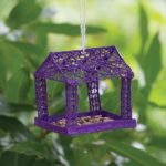 3D art: Purple bird feeder hanging from tree with green background