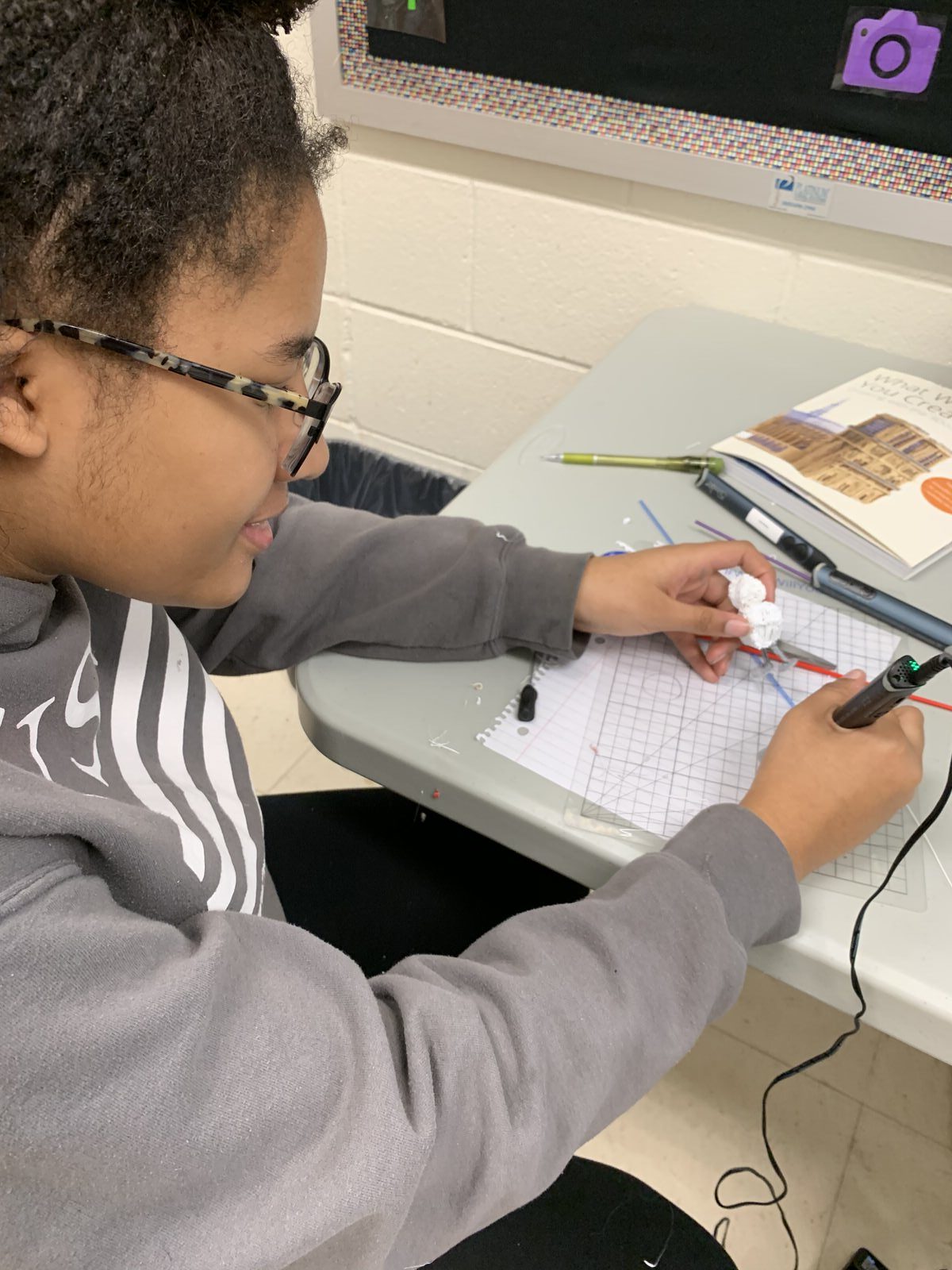 Girl creating cell phone art with 3D pen